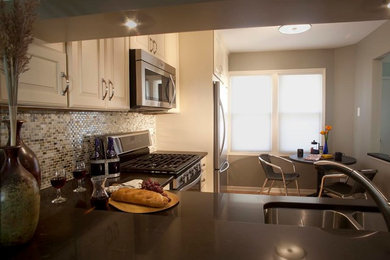 Inspiration for a small transitional l-shaped light wood floor eat-in kitchen remodel in Chicago with a double-bowl sink, raised-panel cabinets, white cabinets, solid surface countertops, multicolored backsplash, stone tile backsplash and stainless steel appliances