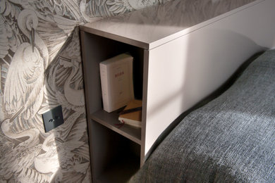 Exemple d'une grande chambre parentale tendance avec un mur gris et un sol en bois brun.