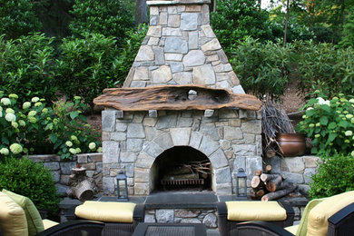Large eclectic backyard patio in DC Metro with a fire feature and natural stone pavers.