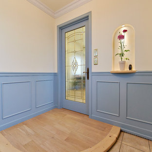 他の地域のトラディショナルスタイルのおしゃれな玄関 (マルチカラーの壁、茶色い床) の写真