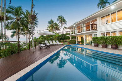Design ideas for a tropical two-storey concrete white exterior in Cairns with a flat roof.