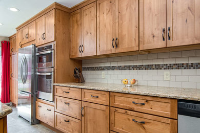 Mid-sized elegant l-shaped ceramic tile and multicolored floor enclosed kitchen photo in Other with an undermount sink, shaker cabinets, medium tone wood cabinets, quartz countertops, white backsplash, ceramic backsplash, stainless steel appliances, an island and multicolored countertops