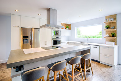 Modern kitchen in Montreal with white cabinets, with island, brown floor and white benchtop.