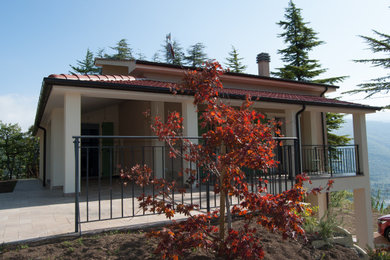 Immagine della facciata di una casa bifamiliare beige mediterranea a due piani di medie dimensioni con tetto a padiglione, copertura in tegole e tetto rosso