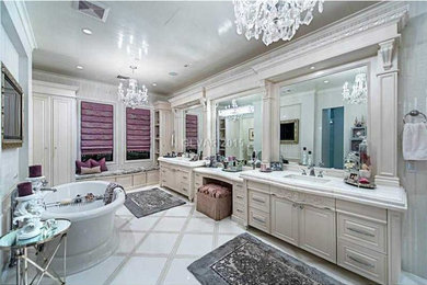 Design ideas for a large transitional master bathroom in Las Vegas with raised-panel cabinets, white cabinets, a freestanding tub, a double shower, a two-piece toilet, white tile, marble, white walls, marble floors, an undermount sink, marble benchtops, white floor and a hinged shower door.