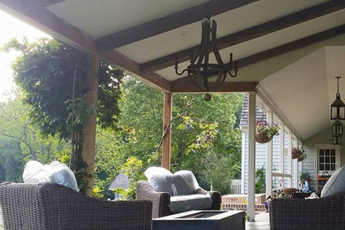 Inspiration for a mid-sized timeless backyard concrete paver patio remodel in Philadelphia with a fire pit and a roof extension