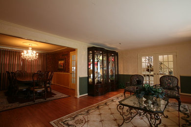 Example of a classic medium tone wood floor living room design in Philadelphia with multicolored walls, a standard fireplace and a wood fireplace surround