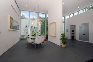 Inspiration for a large 1950s porcelain tile and gray floor dining room remodel in Miami with white walls and no fireplace