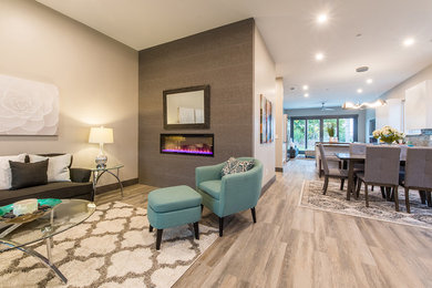 Mid-sized trendy open concept laminate floor and brown floor living room photo in San Diego with gray walls, a ribbon fireplace, a metal fireplace and no tv