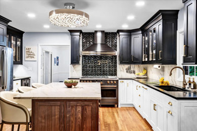 Example of a large transitional u-shaped light wood floor and yellow floor eat-in kitchen design in Louisville with a double-bowl sink, shaker cabinets, soapstone countertops, white backsplash, ceramic backsplash, black appliances, an island and black countertops