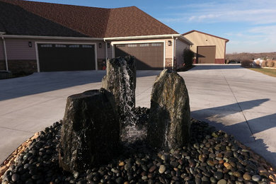 This is an example of a large traditional full sun front yard gravel landscaping in Other for summer.