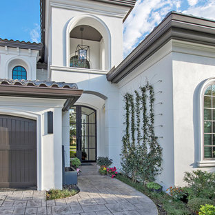 Design ideas for a large mediterranean two-storey stucco white house exterior in Tampa with a hip roof and a tile roof.