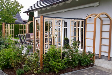 Mittelgroßer Landhaus Garten im Frühling mit Auffahrt, direkter Sonneneinstrahlung und Natursteinplatten in Berlin
