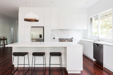 Photo of a large contemporary l-shaped open plan kitchen in Melbourne with a single-bowl sink, white cabinets, marble benchtops, stone slab splashback, stainless steel appliances, dark hardwood floors and with island.