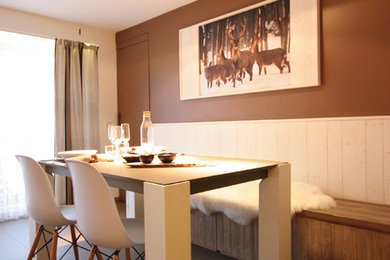 Foto di un'ampia sala da pranzo aperta verso il soggiorno rustica con pareti marroni e pavimento in gres porcellanato