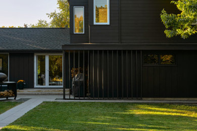 Inspiration for a mid-sized scandinavian black two-story concrete fiberboard and clapboard exterior home remodel in Minneapolis with a shingle roof and a black roof