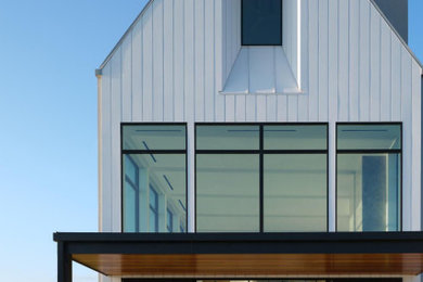 Example of a trendy white house exterior design in Baltimore with a gray roof