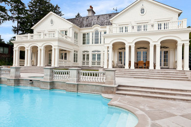 Large elegant backyard concrete paver and custom-shaped lap hot tub photo in Toronto