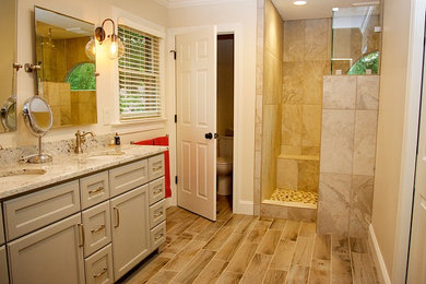 Bathroom - mid-sized contemporary master beige tile, gray tile and ceramic tile laminate floor and brown floor bathroom idea in Other with recessed-panel cabinets, gray cabinets, a two-piece toilet, beige walls, an undermount sink and granite countertops