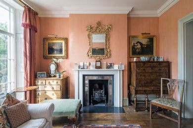 Design ideas for a large traditional formal enclosed living room in London with orange walls, dark hardwood floors, a standard fireplace, a metal fireplace surround and no tv.