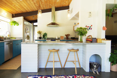 Mid-sized midcentury u-shaped kitchen in Los Angeles with flat-panel cabinets, blue cabinets, stainless steel appliances, concrete floors, a peninsula, marble benchtops, window splashback and grey floor.