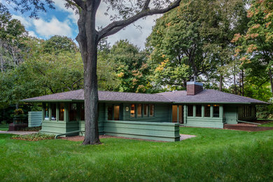 Inspiration for a mid-sized craftsman green one-story wood house exterior remodel in Minneapolis with a hip roof and a shingle roof