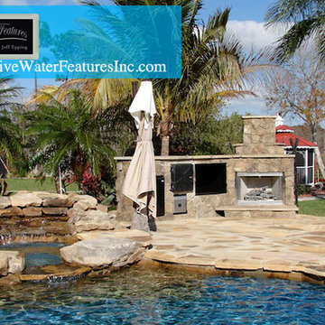 Tropical backyard room with pool waterfall, fireplace, and koi pond