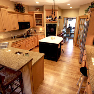 Large traditional u-shaped kitchen pantry in Cleveland with quartz benchtops, beige splashback, glass sheet splashback, black appliances and with island.