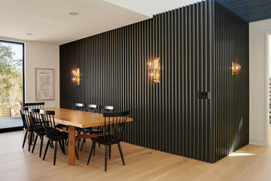 Mid-sized 1960s light wood floor and wall paneling kitchen/dining room combo photo in Austin with gray walls