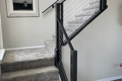 Inspiration for a large modern metal l-shaped metal railing staircase remodel in Boise with carpeted risers