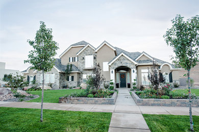Large elegant brown two-story stone exterior home photo in Salt Lake City