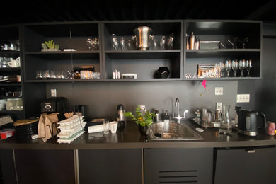Kitchen - industrial kitchen idea in New York with black backsplash and mirror backsplash