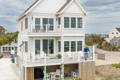 Foto de fachada de casa costera de dos plantas con revestimientos combinados, tejado de teja de madera y panel y listón