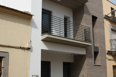 Imagen de fachada gris contemporánea pequeña de dos plantas con revestimientos combinados y tejado a dos aguas
