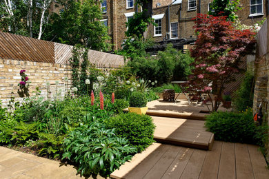 Inspiration for a small modern back partial sun garden for summer in London with a wood fence.