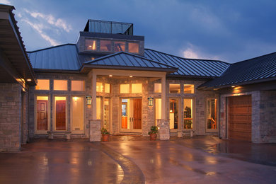 Example of a huge trendy beige two-story stone exterior home design in Other with a hip roof