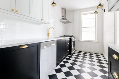 Example of a small minimalist galley laminate floor and multicolored floor enclosed kitchen design in New York with an undermount sink, shaker cabinets, black cabinets, quartzite countertops, white backsplash, subway tile backsplash, stainless steel appliances, no island and white countertops