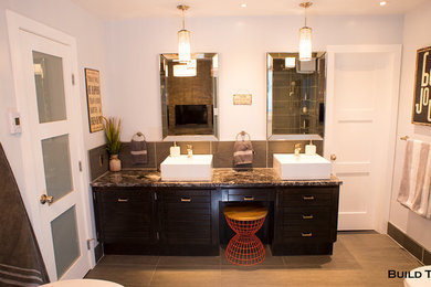 Example of a large trendy master gray tile and stone tile ceramic tile and gray floor bathroom design in Other with flat-panel cabinets, dark wood cabinets, a two-piece toilet, gray walls, a vessel sink and granite countertops