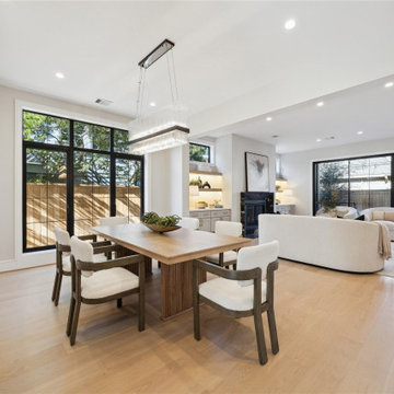 Open dining area with warm walnut table and statement linear pendant