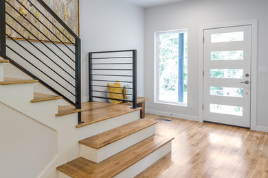 Mid-sized 1950s light wood floor entryway photo in Other with white walls and a white front door