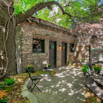 Original brick garage and massive green ash frame the private back yard