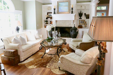 Mid-sized elegant open concept medium tone wood floor and brown floor family room photo in Seattle with green walls, a standard fireplace, a stone fireplace and no tv