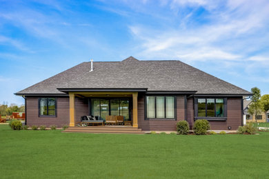 Imagen de fachada de casa marrón y gris clásica renovada de una planta con revestimientos combinados y tejado de teja de madera