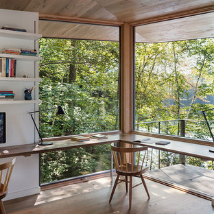 На фото: кабинет в стиле модернизм с белыми стенами, паркетным полом среднего тона, встроенным рабочим столом и коричневым полом с