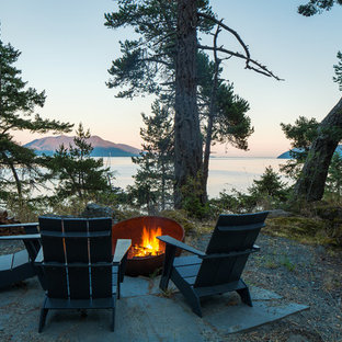 Design ideas for a mid-sized country backyard patio in Seattle with natural stone pavers and no cover.