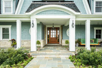 Large traditional blue wood exterior home idea in Milwaukee with a gambrel roof