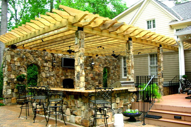 Patio kitchen - mid-sized rustic backyard concrete paver patio kitchen idea in Other with a pergola