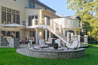Example of a large transitional backyard patio design in DC Metro with a roof extension
