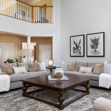 Neutral Two Story Family Room with Tufted Wing Chairs