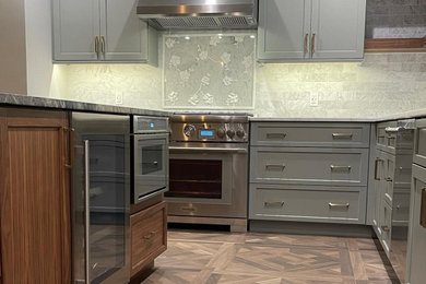 Transitional porcelain tile and brown floor kitchen photo in New York with shaker cabinets, green cabinets, marble countertops, white backsplash, marble backsplash, stainless steel appliances, an island and white countertops